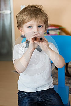 Little boy playing wooden flute indoor