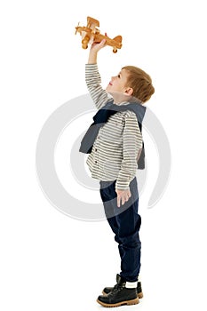 Little boy playing with wooden plane