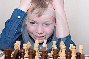A little boy plays chess, but he doesnâ€™t succeed