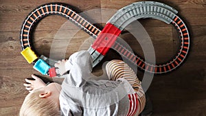 A little boy plays a children`s railway. Mom is watching her son from above. The child is fascinated by the train