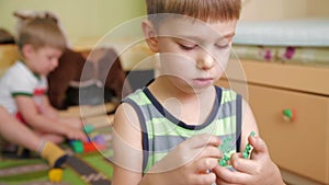 Little boy plays with constructor on the floor