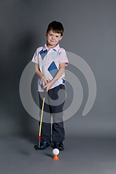 Little boy plays mini golf