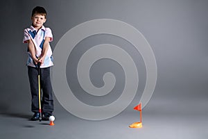 Little boy plays mini golf
