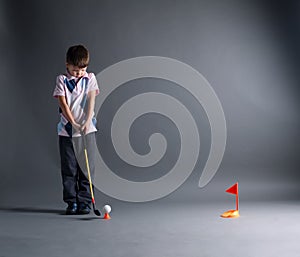 Little boy plays mini golf