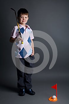 Little boy plays mini golf