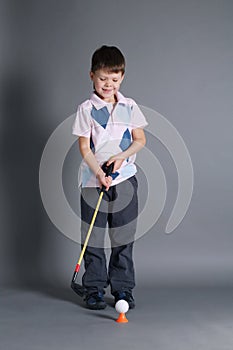 Little boy plays mini golf