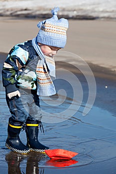 Little boy plays with paper ships