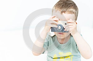 The little boy plays photographer with toy wooden camera