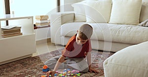 Little boy plays with plastic multicolored construction toy set