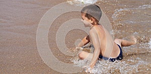 Little boy plays in the sea