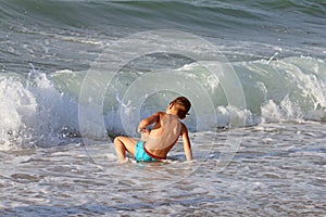 Little boy plays in sea