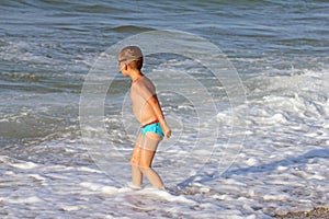 Little boy plays in sea