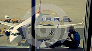 Little boy plays with tablet, while waiting for the plane to fly. 4K.