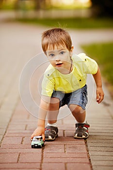 Little boy plays with toy car