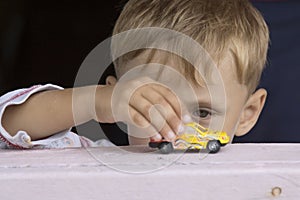 Little boy plays a toy car