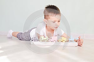 Little boy plays with toy car at home
