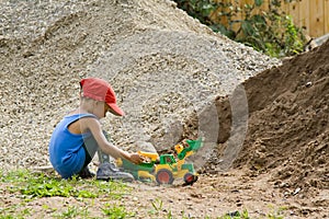 Little boy plays with a toy tractor photo