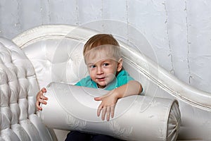 A little boy plays with a white pillow