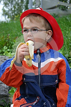 Little boy pleasurably bites into a banana