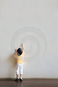 The little boy pointed at the blank white wall