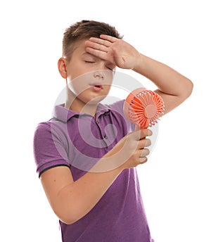 Little boy with portable fan suffering from heat on background. Summer season