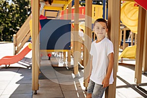 Little boy poses on playground, happy childhood