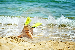 Little boy posing on the beach wearing snorkeling equipment. On the background of the sea