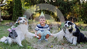 Little boy posing with his dogs in nature.