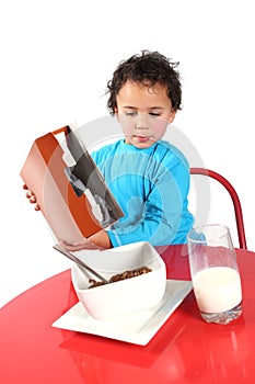 Little boy pouring breakfast cereal