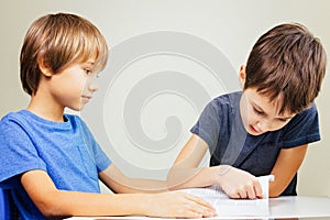 Little boy practice reading with his brother at home