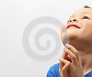 Little boy praying with his hands clenched together