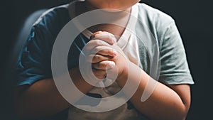 Little boy praying to God with hands held together. Child worship to God. Cute little boy in a Christian family