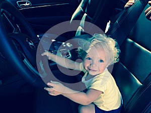 A Little Boy Pretending to Drive a Car