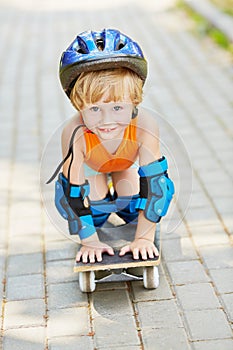 Little boy in protective helmet stands on knees