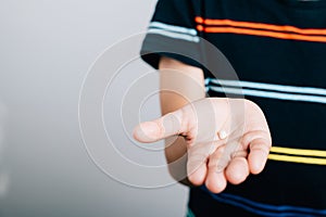 Little boy proudly holds fallen baby tooth emphasizing dental hygiene. First