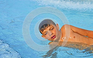 Little boy in the public swimming pool. Portrait of little boy in the swimming pool. Sunny summer day. Summer and happy chilhood c