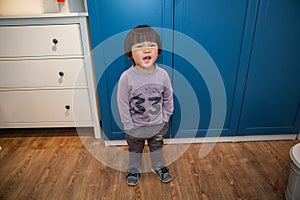 Little boy in a purple coat playing in the living room