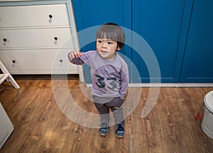 Little boy in a purple coat playing in the living room