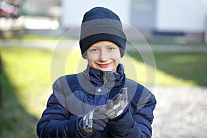 Little boy putting on mitten photo