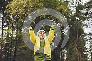 little boy in raincoat celebrating