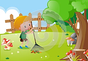 Little boy raking leaves in garden