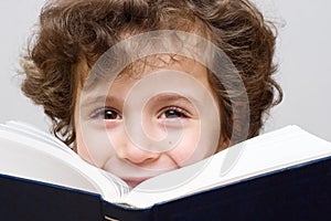 A little boy reading a big book