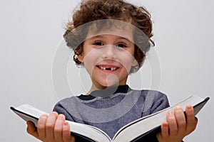 A little boy reading a big book