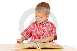 Little boy reading book on the desk