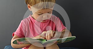 Little boy reading book of tales