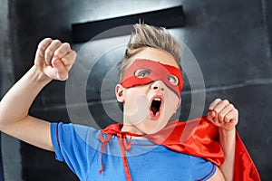 little boy in red superhero costume gesturing