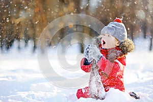 Little boy in red winter clothes having fun with snow photo