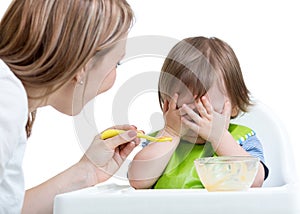 Little boy refuses to eat closing face by hands
