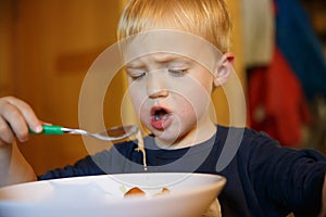 Little boy refusing to eat by himself