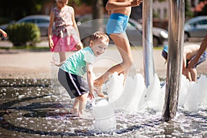 Little boy rejoices at the bubbles and bulbs of the city fountain